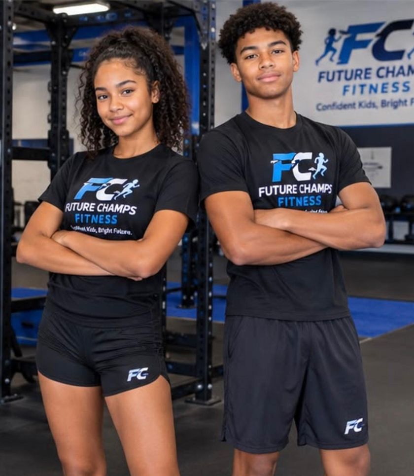 Two teenagers in Future Champs Fitness shirts standing with their arms crossed